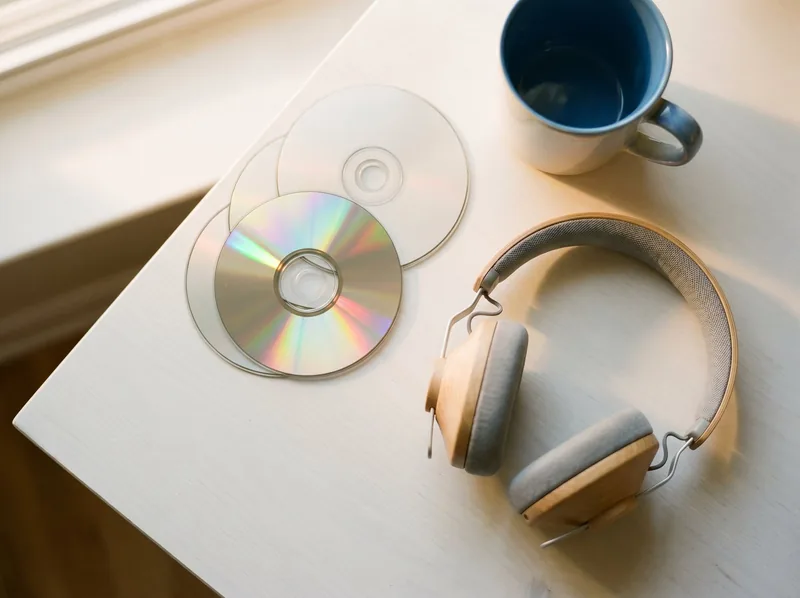 CDs and headphones on a bright desk